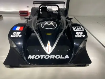 Front view of black Motorola-liveried Lola LMP prototype number 25 with silver V graphic and elf decals