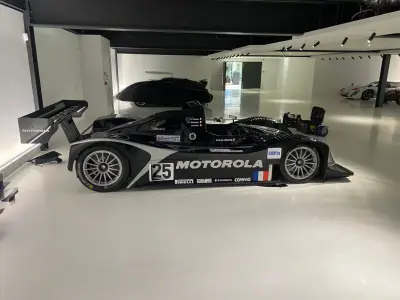 Side profile of black Motorola-liveried Lola LMP prototype number 25 with large rear wing