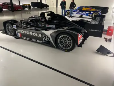 Black Motorola Lola LMP sports-prototype number 25 being detailed in a showroom