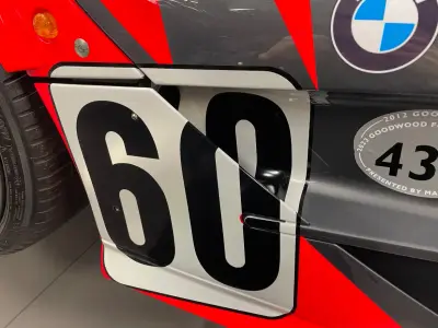 Close-up of black number 60 on white door panel of BMW-liveried McLaren race car