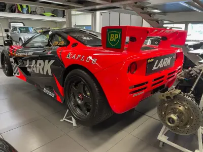 Red and black Lark McLaren F1 GTR rear three-quarter in Lanzante workshop, BP and Bridgestone livery