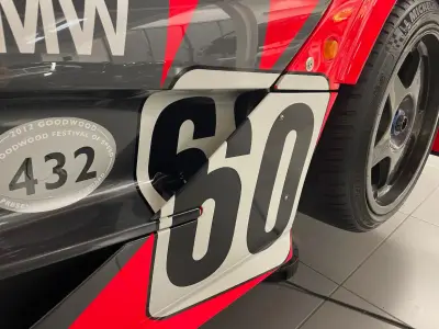 Number 60 panel close-up on grey BMW McLaren livery beside Michelin race tyre