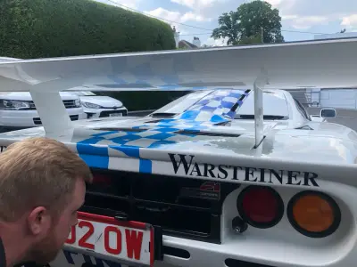 Rear of white McLaren F1 GTR with Warsteiner wing lettering and blue checkered graphics