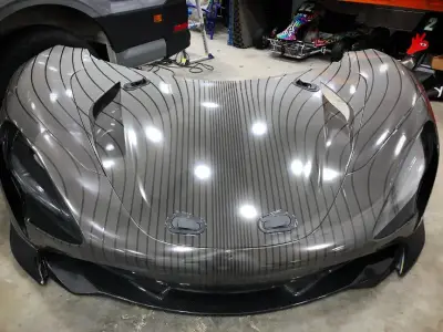 Silver pinstripe-wrapped McLaren Speedtail front bodywork under workshop lights