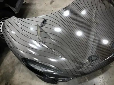 Grey pinstripe vinyl-wrapped McLaren Speedtail front corner in workshop
