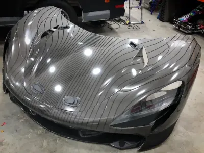 Grey pinstripe-wrapped McLaren Speedtail front bodywork and carbon splitter in workshop