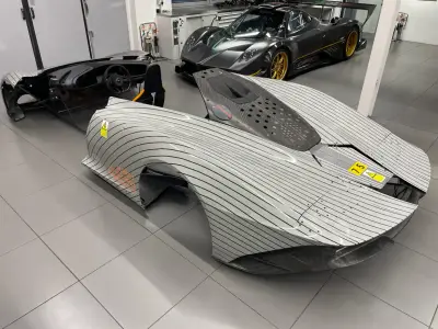 Overhead view of silver pinstripe-wrapped McLaren Speedtail panels, Pagani Zonda behind