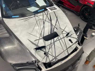 Porsche 935 grey bonnet with black scratch-line livery mid-application in workshop