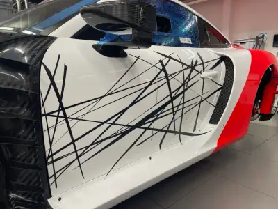 White Porsche 935 side panel with black abstract line graphics and red accent