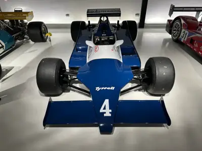 Blue Tyrrell Formula 1 car front, number 4, on display in showroom