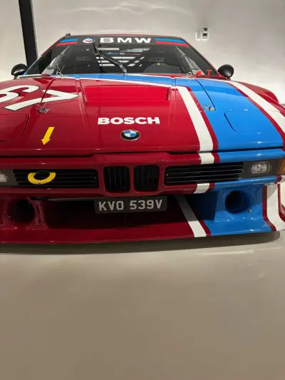 Close front of red BMW M1 race car with BMW and Bosch livery, plate KVO 539V