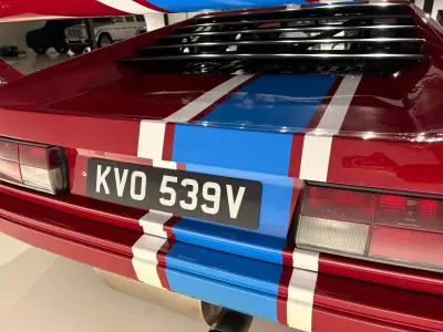 Rear detail of red BMW M1 race car, blue stripe and plate KVO 539V