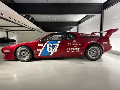 Full side of red BMW M1 Procar number 67 with Crevier Racing race livery