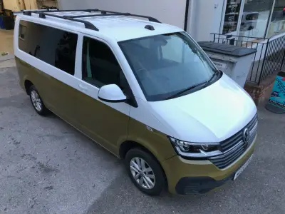 Two-tone white-over-gold VW Transporter van, front three-quarter view