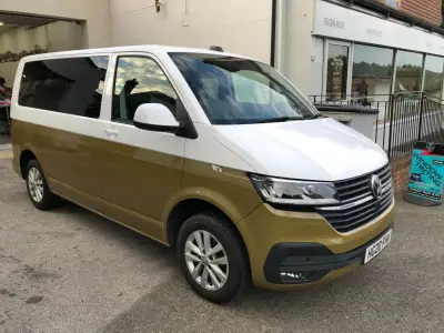 White-and-gold VW Transporter van parked outside V Signs signage workshop