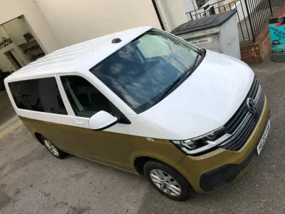 Overhead front view of two-tone white-over-gold VW Transporter van