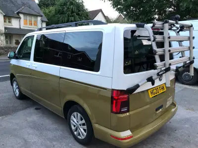 Rear of two-tone white-over-gold VW Transporter van with aluminium bike rack