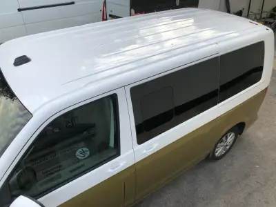 Roof and side of two-tone VW Transporter van showing tinted windows