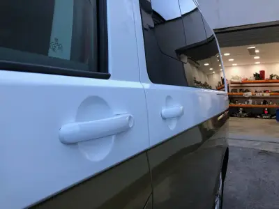Side detail of white-and-gold VW Transporter door handles and two-tone paint line