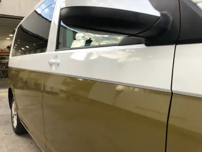 Close-up of VW Transporter van in two-tone olive green and white part wrap