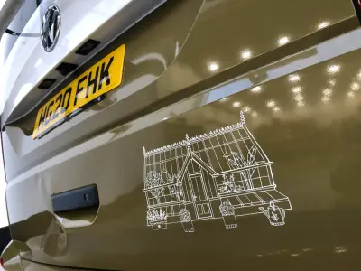 Olive green wrapped VW van tailgate with white line-drawing of a greenhouse graphic