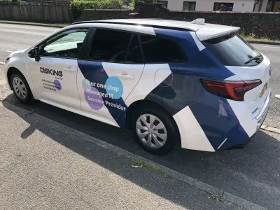White Toyota Corolla estate wrapped with DISKING managed IT service graphics