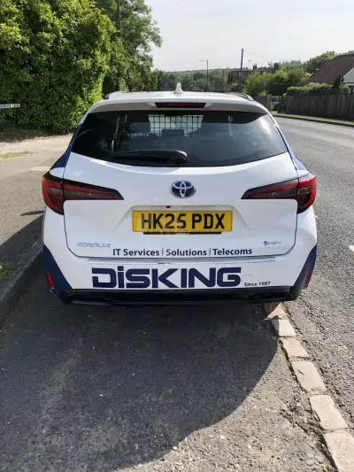 Rear of white Toyota Corolla Hybrid estate with DISKING IT Services signwriting
