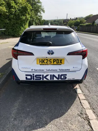 Rear of white Toyota Corolla estate with blue DISKING IT Services graphics
