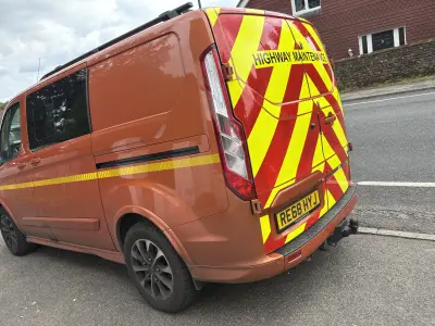 Orange Ford Transit Custom with red and yellow chevron Highway Maintenance rear markings