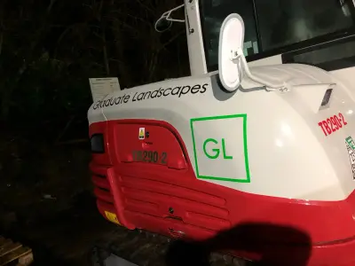 'Graduate Landscapes' name and green GL logo cut vinyl on a red-and-white Takeuchi excavator