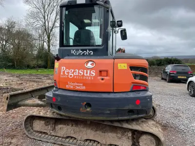 Orange Kubota excavator with white 'Pegasus Builders' graphics on the rear counterweight