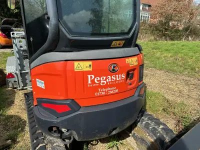 'Pegasus Builders Est 1979' white graphics on the orange rear panel of a Kubota excavator