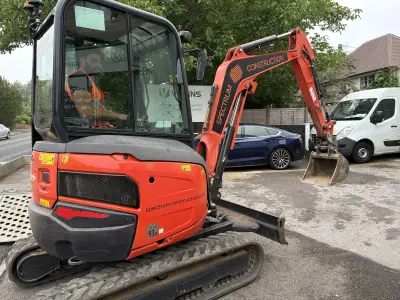 Orange Kubota excavator with 'spectrumconstruction.co.uk' decal and Spectrum Construction boom graphics