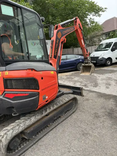 Kubota excavator branded 'Spectrum Construction' with a VSigns signboard in the background
