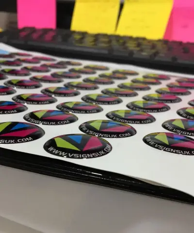 Sheet of domed resin badge stickers printed with the VSigns logo and www.vsignsuk.com