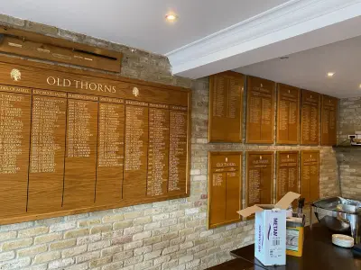 Old Thorns golf club oak honours boards with engraved gold winners' names on a brick wall