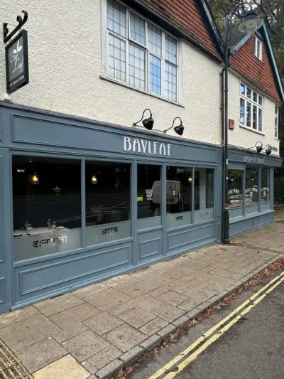 Grey 'Bayleaf' Indian restaurant shopfront fascia with silver lettering and Hindi window graphics