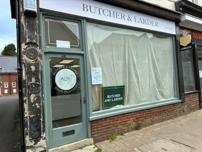 Butcher & Larder green shopfront with fascia sign and etched cow logo door graphic