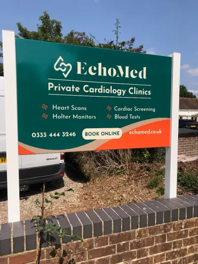 EchoMed Private Cardiology Clinics green post-mounted sign above a brick wall