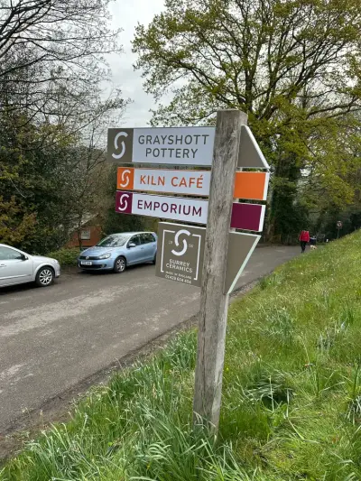 Grayshott Pottery multi-business wayfinding fingerpost sign beside a lane
