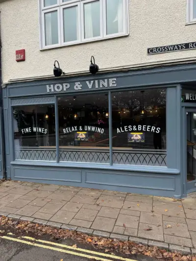 Hop & Vine grey shopfront with signwritten fascia and Fine Wines window graphics