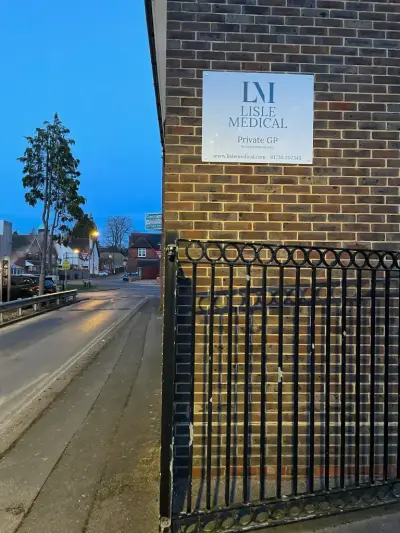 Lisle Medical Private GP wall sign on brick beside a street at evening
