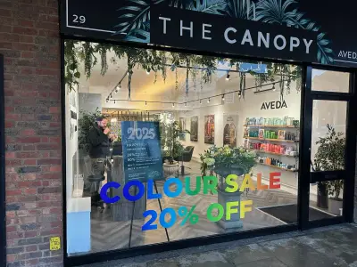The Canopy salon window graphics with a rainbow Colour Sale 20% Off promotion, Aveda stockist