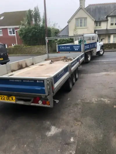 EAVOAK blue flatbed truck and matching flatbed trailer with white side and rear graphics