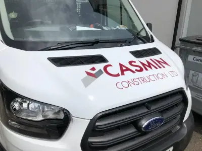 Casmin Construction Ltd red and grey logo on a white Ford Transit bonnet