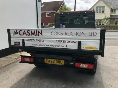 Casmin Construction Ltd rear dropside signwriting with phone numbers and website