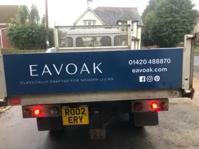 Rear of a tipper truck with blue Eavoak tailgate panel and white classically-crafted strapline