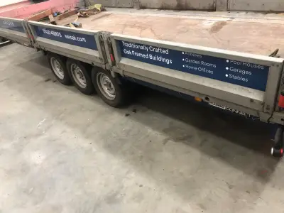Blue Eavoak oak-framed-buildings signage panels fitted to a galvanised flatbed trailer