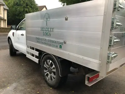 White Ford Ranger tipper with silver dropside and green Headley Logs signwriting, rear angle