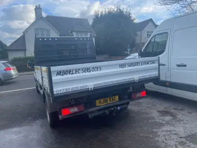 Rear of a white Ford tipper with grey Arborlec Services tree surgery and fencing signwriting